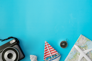 camera, map and souvenirs on a blue background
