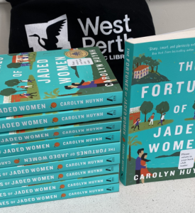 photograph of a pile of 10 copies of a book along with a book bag