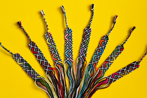 a number of braided bracelets on a yellow background