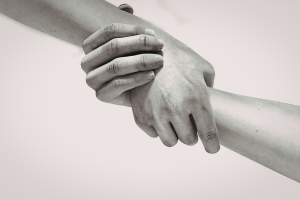 photograph of two hands, each grasping the wrist of the other