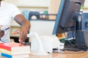 library items being checked out with a scanner at a computer