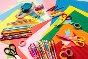 picture of an assortment of craft supplies including scissors, paper, marker and crayons