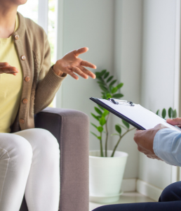 Photograph of two people talking, one is holding a clipboard