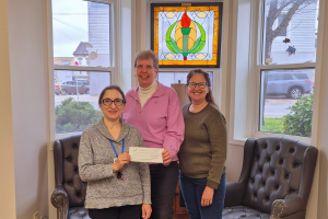 picture of 2 people presenting cheque to library CEO