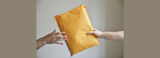 photograph of a package being handed from one person to another
