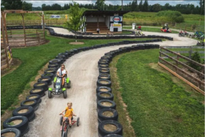 photograph of a track lined with tires and people riding 3 or 4 wheel bikes