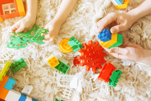 children playing with blocks on rug