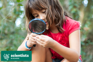 photo of a girl examing something through a magnifying glass