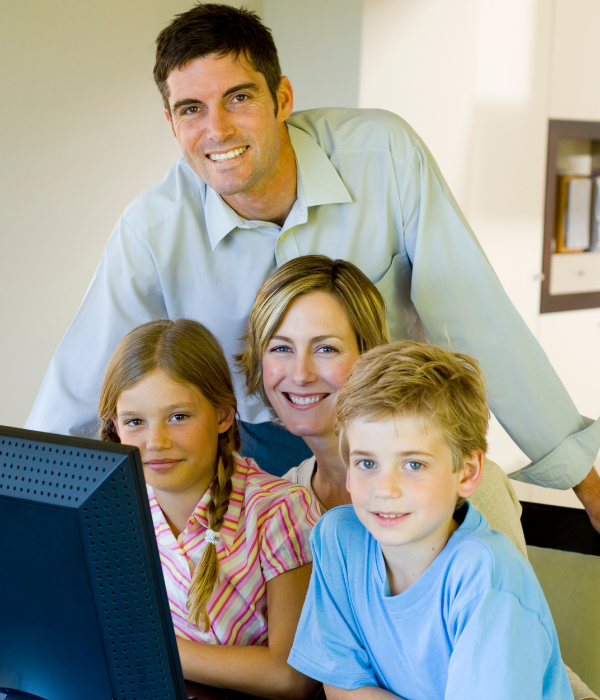 2 adults and 2 children sitting at a computer