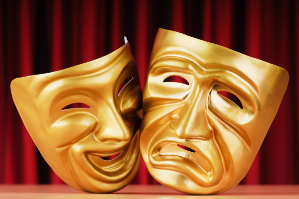 comedy and tragedy masks against a red curtain